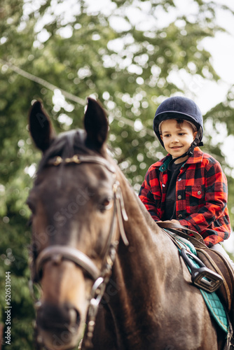 Boy riding a horse on ranch © Petro