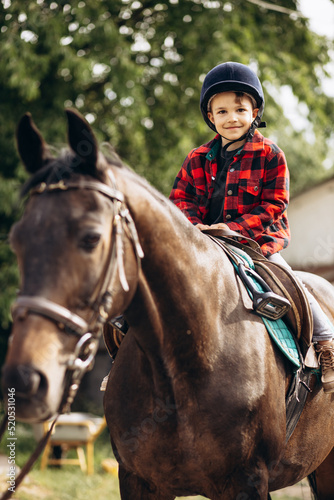 Boy riding a horse on ranch © Petro