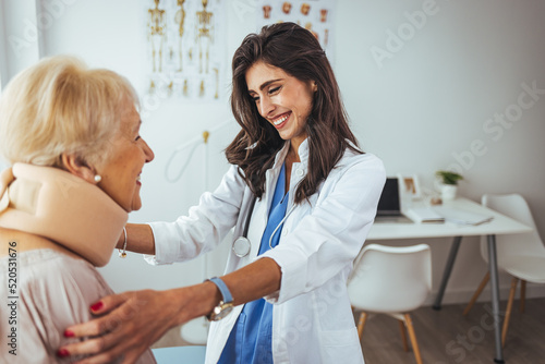 Portrait of a female doctor helping a senior woman at office with her neck injury and putting her collar a healthcare and medicine concepts. Doctor putting a neck brace on a senior patient