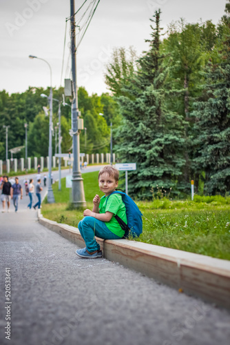 Portrait of a child, a boy against the backdrop of urban landscapes of skyscrapers and high-rise buildings in the open air. Children, Travel. Lifestyle in the city. Center, streets.