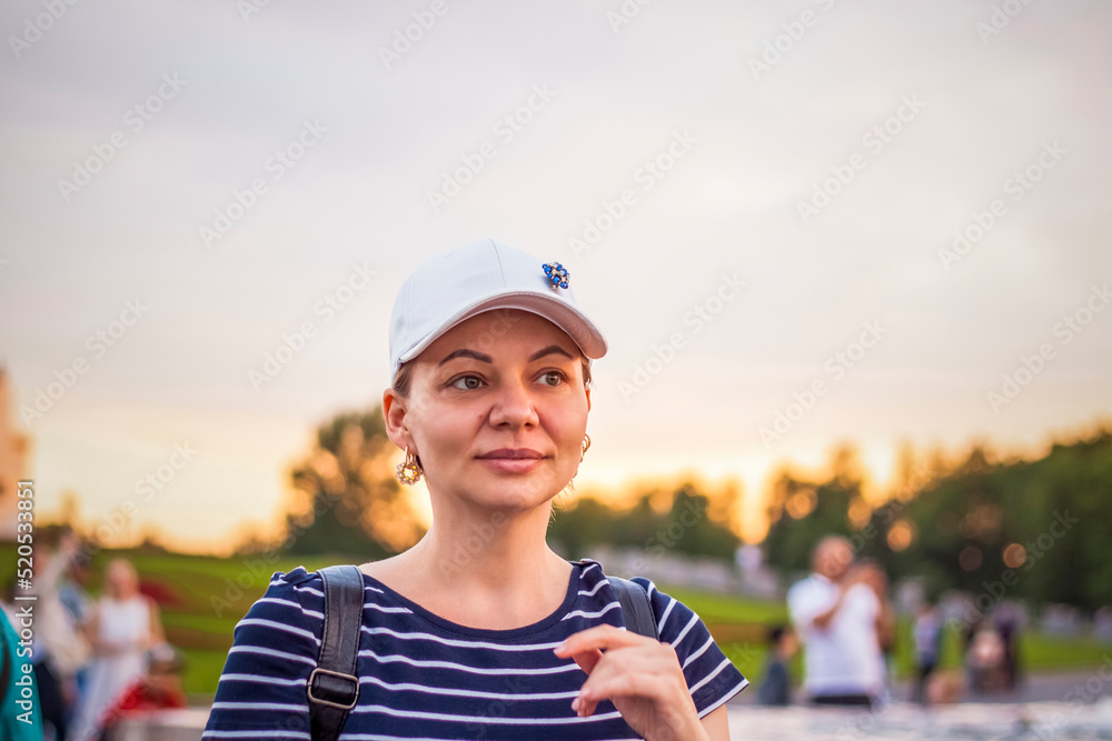 Portrait of a girl in a cap on the background of an open-air urban landscape. Travel. Lifestyle in the city. Center, streets