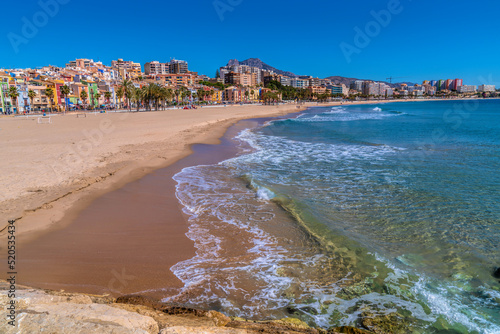 Villajoyosa Spain beautiful sandy beach and clear blue sea with colourful houses and palm trees Costa Blanca Alicante photo