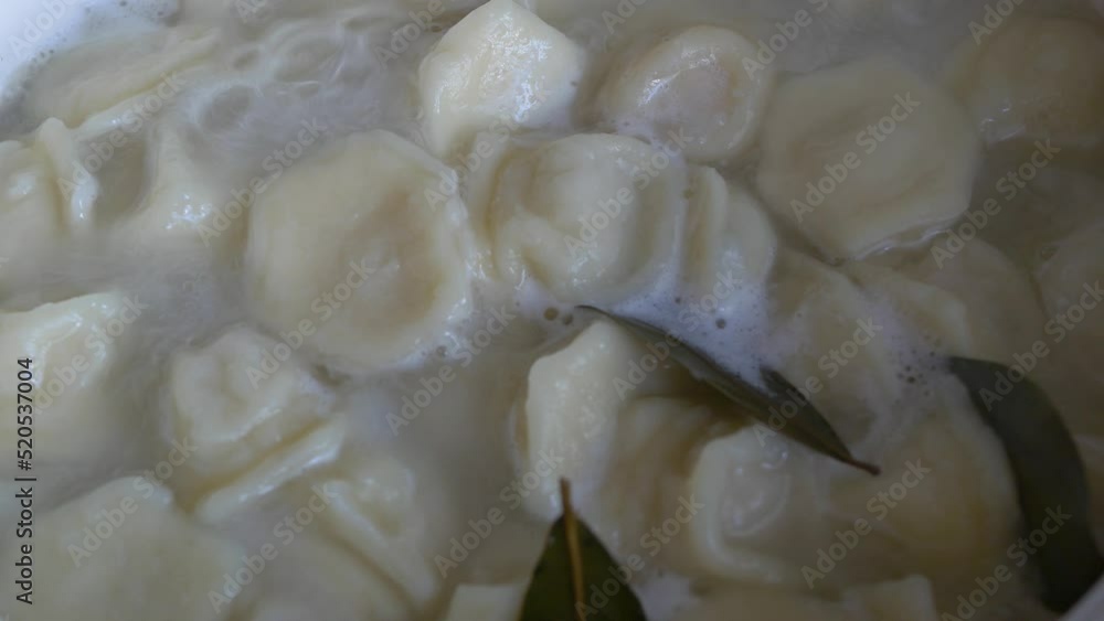 The cook cooks dumplings, close-up, selective focus. The cook cooks dumplings, close-up, selective focus.