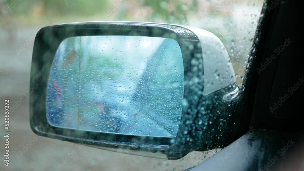 Rear view mirror of a car in water drops during rain Rear view mirror of a car in water drops during rain