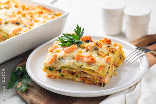 Lasagna with salmon fish, zucchini, bechamel sauce, parmesan cheese and leek. Baked in an oven italian pasta made of flat sheets.
