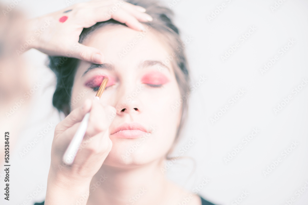 Makeup artist applies bright red eyeshadow. Close-up. Makeup artist applies bright red eyeshadow. Close-up.