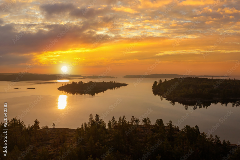 Nature Karelia. Lake Ladoga aerial photography. Landscape Russia. Sunset over Karelia. Panorama with lake Ladoga view from drone. Evening sky over Karelia. Sun is reflected in water. Regions Russia