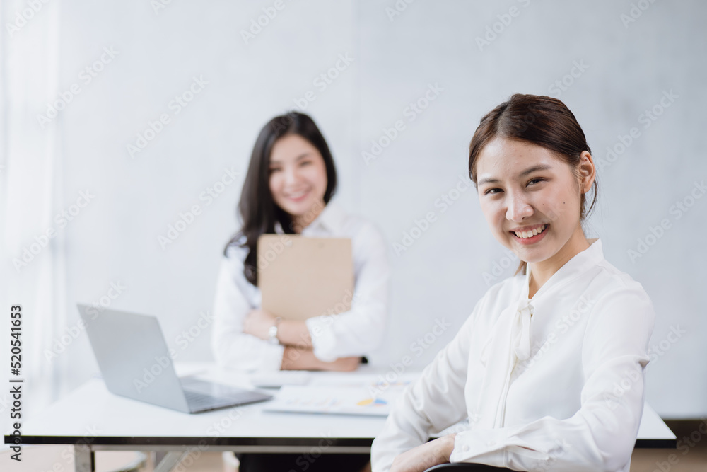Happy young business women are discussed and working on laptop in office space. Happy young business women are discussed and working on laptop in office space.
