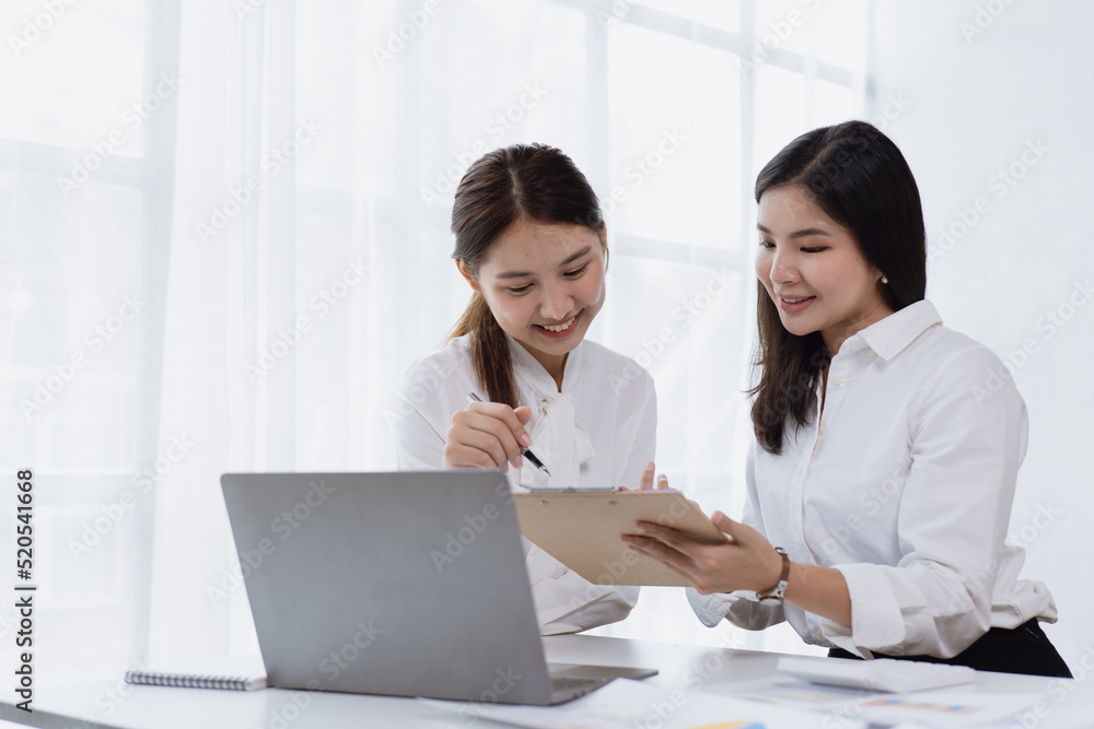 Happy young business women are discussed and working on laptop in office space. Happy young business women are discussed and working on laptop in office space.