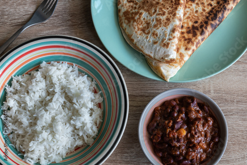 Fotografie, Obraz Chili con carne in a bowl accompanied by white rice and quesadillas