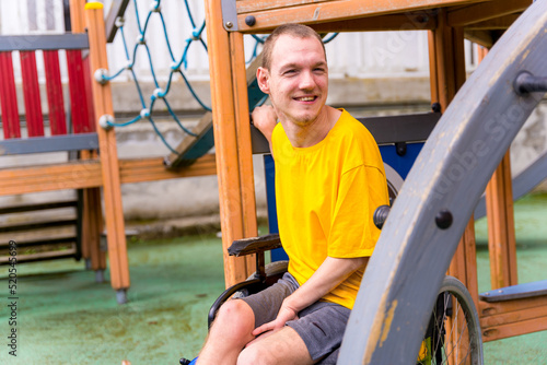 A disabled person in a wheelchair on the swings of a playground