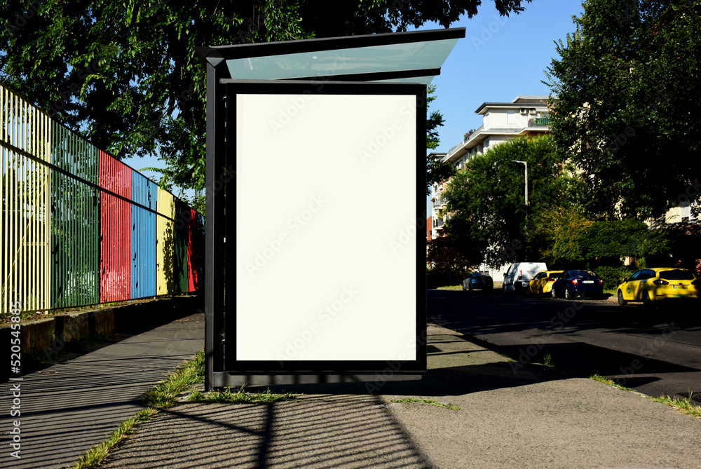 bus shelter at a busstop. blank billboard ad display. empty white lightbox sign. ad space. city transit station. glass structure. urban street setting. outdoor advertising  concept.