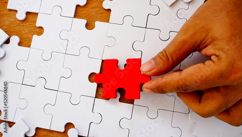 Hand try to put and lay the jigsaw on missing area