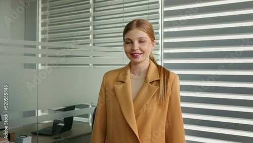 Portrait of business woman smiling on camera standing in office. Business lady in modern office. Workplace photo