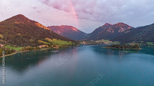 Dawn light with rainbow at the romantic lake of Schliersee in south Germany, near the Alps