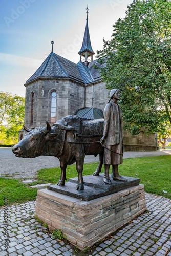 Vertical shot of a cow and girl statue at llen church in Trondheim City, Norway photo