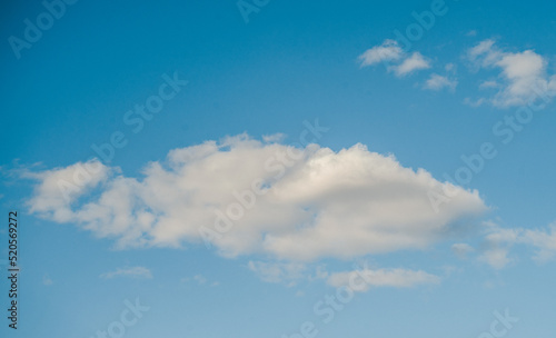 a large white cloud in the blue sky on a bright sunny day.