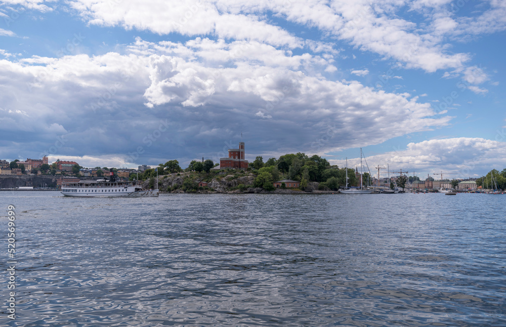 Old steam commuting boat passing a castle in a sunny summer day in Stockholm