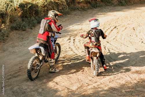 Live shot of junior sportsman, motorcyclist training on motorbike at hot summer day, outdoors. Motocross rider in action. Motocross sport, challenges