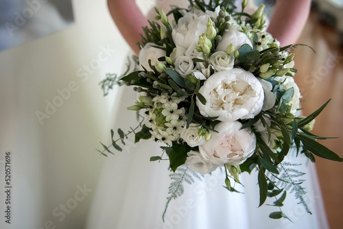 Fototapeta Naklejka Na Ścianę i Meble -  Beautiful bouquet of peonies in the bride's hands