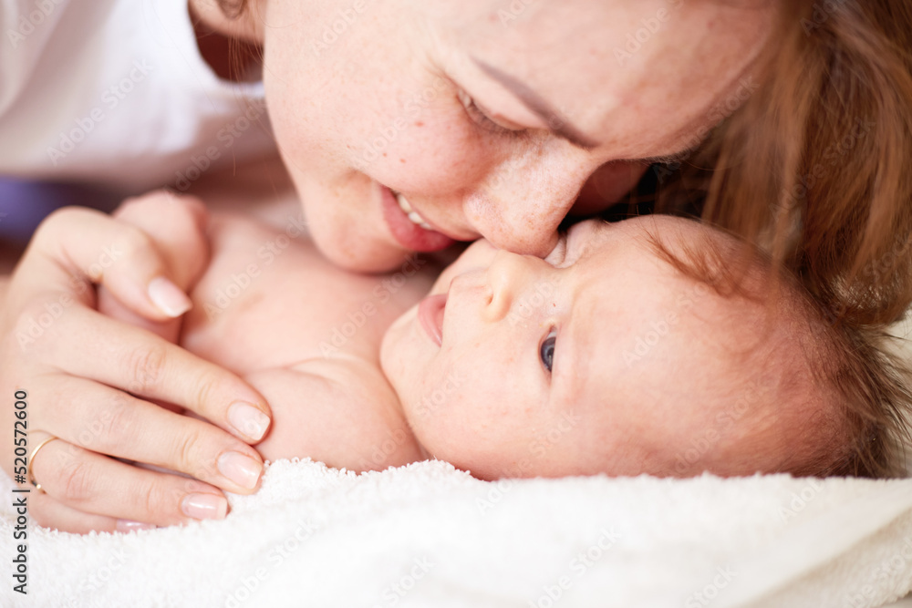 Mother Massaging Her newborn baby boy. Realistic home portrait Mother Massaging Her newborn baby boy. Realistic home portrait