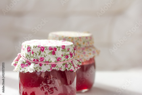 Fabric wrapped jars. Preserved berries, homemade jam. Copy space, stock photo