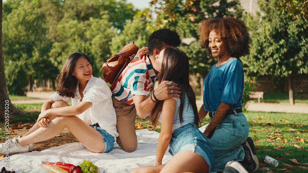 Happy smiling young multinational people at picnic on summer day outdoors. Friends have fun weekend together, relaxing in the park at picnic Happy smiling young multinational people at picnic on summer day outdoors. Friends have fun weekend together, relaxing in the park at picnic