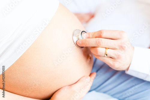 Doctor consultation pregnant woman. Medical clinic for pregnancy consultant. Doctor examining pregnancy woman belly holding stethoscope. Concept maternity, pregnancy, childbirth.