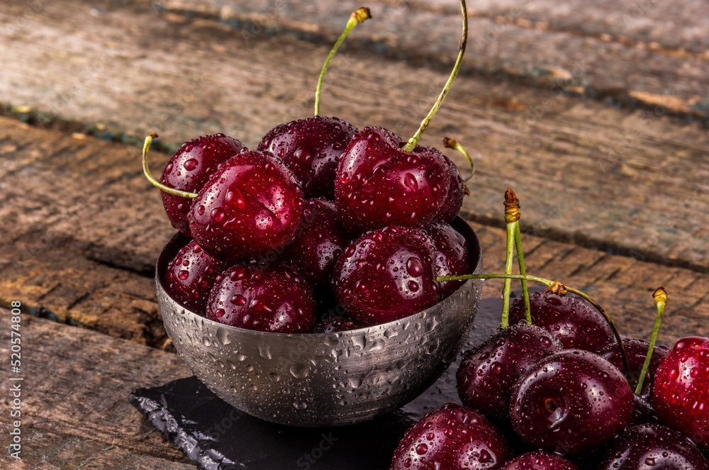 A bowl of large juicy dark red cherries close-up