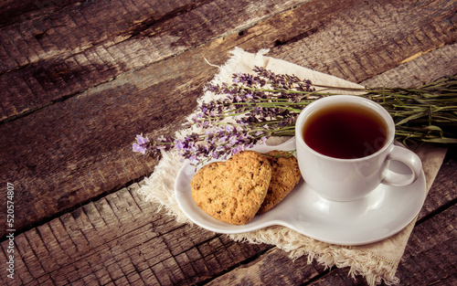 Obraz na płótnie Cup of tea with lavender and cookies on a wooden table. w salonie