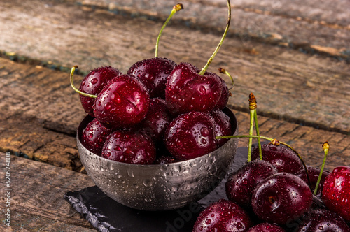 A bowl of large juicy dark red cherries close-up