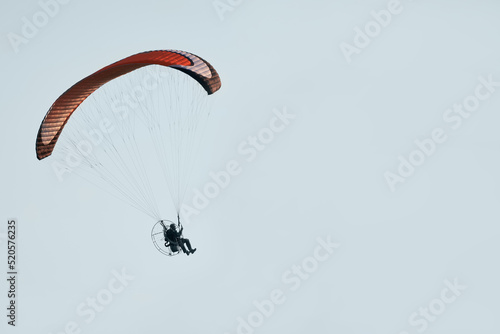 Route flight of a paraglider. A motorcycle paraglider in the air, against the sky. Copy space.