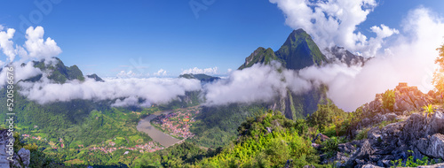 View from the top Viewpoint of Nong Khiaw - a secret village in Laos. Stunning scenery of limestone cliff valley covered with green rainforest jungle mysterious clouds.