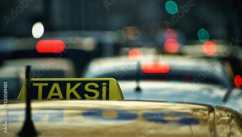 Foto Taxi sign on the top of the yellow car against a blurred background,
translation