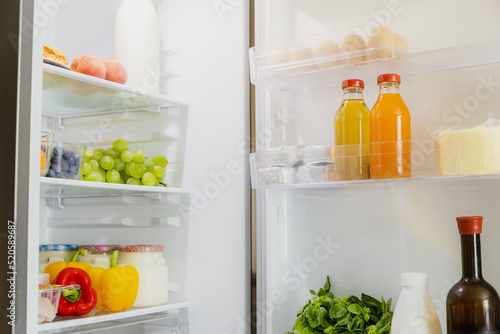 Front View of open two door fridge or refrigerator door filled with fresh fruits and vegetables, full of healthy food items and ingredients inside. Electric Kitchen and Domestic Major Appliances