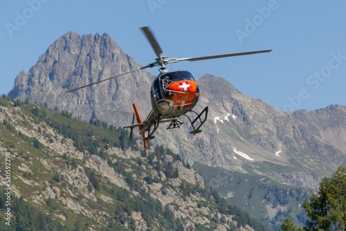 Chamonix Mont-Blanc Helicopter flying over dense trees and rocky mountains