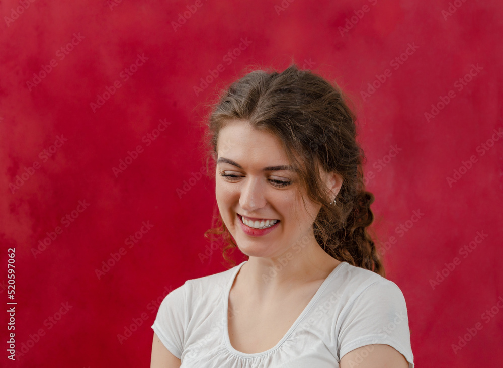 Portrait of a charming young woman. Long, curly dark hair is pulled ...