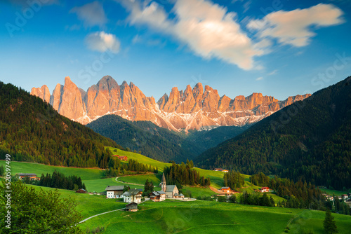 Sunset over the Odle peaks and the alpine village of Santa Magdalena in spring, Funes Valley, South Tyrol, Italy photo