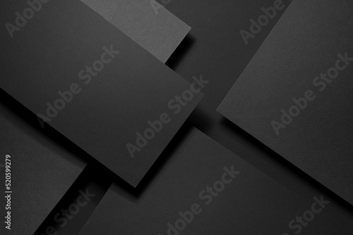 Dark graphite grey abstract textured geometric stepped background with fly rectangle paper sheets, stripe with corner, lines in hard light, black shadows in luxury business style for design, top view.