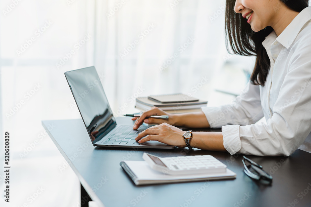 Young Attractive Asian business female finance worker sitting at work, answering e-mails on the tablet. Young Attractive Asian business female finance worker sitting at work, answering e-mails on the tablet.