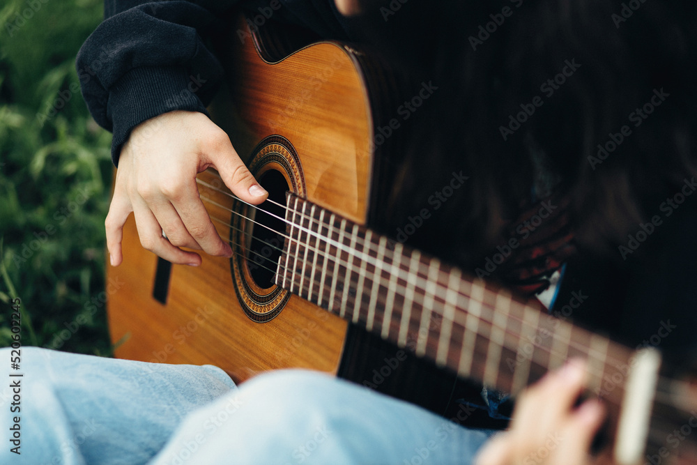 The girl's hands play the guitar