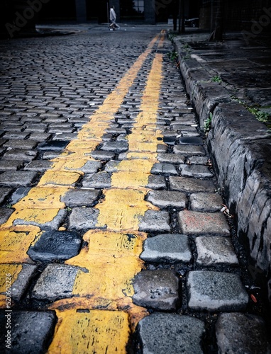 double yellow lines along a cobbled street Fototapet