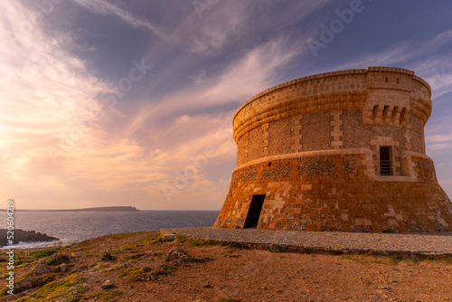 View of Fornelles Tower fortress and Mediterrainean Sea at sunset in Fornelles, Fornelles, Menorca, Balearic Islands, Spain photo