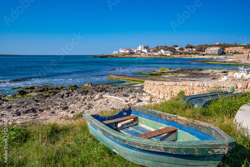 View of Playa Punta Prima and rowing boat on sunny morning, Punta Prima, Menorca, Balearic Islands, Spain photo