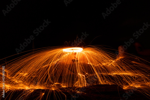 Lighting from spinning steel wool on a stone near the sea of Steel Wool Photography.