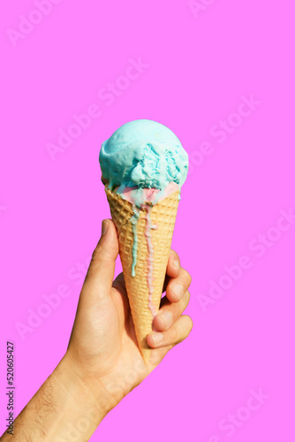 Ice cream cone in hand on minimal color background isolated. Summer, food, sweets, ice cream concept.
