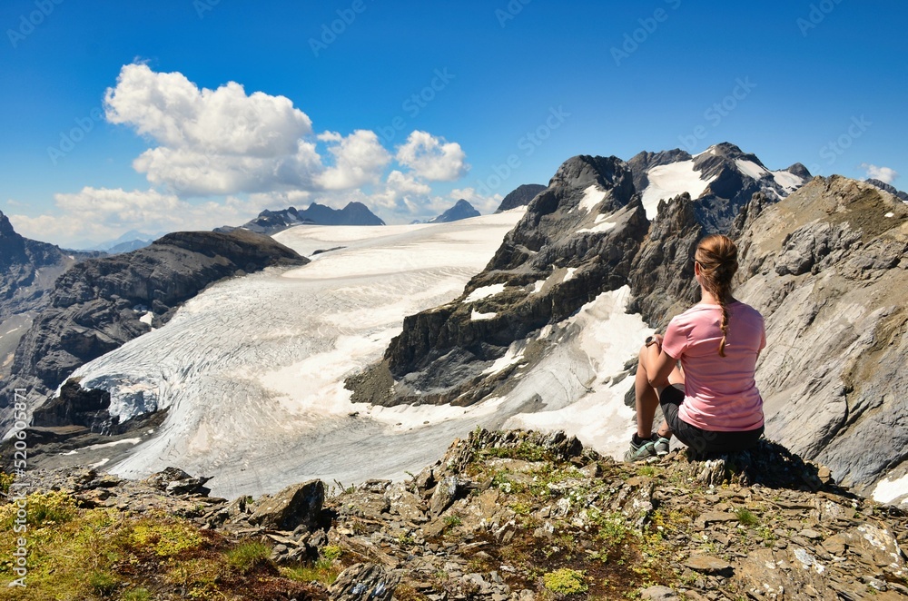 young woman enjoying the view over the mountains and the glacier. Magical moment to enjoy. Swiss Alps.High quality photo