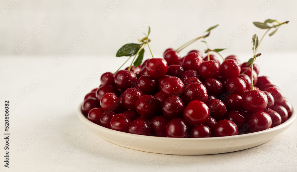 ripe cherries in a plate on a light background ripe cherries in a plate on a light background