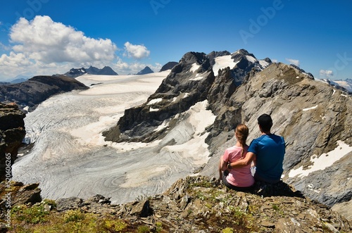young couple enjoys the view of the glacier world. Gemsfairenstock with a view of the Clariden. Mountain panorama