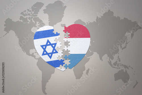 puzzle heart with the national flag of luxembourg and israel on a world map background.Concept.